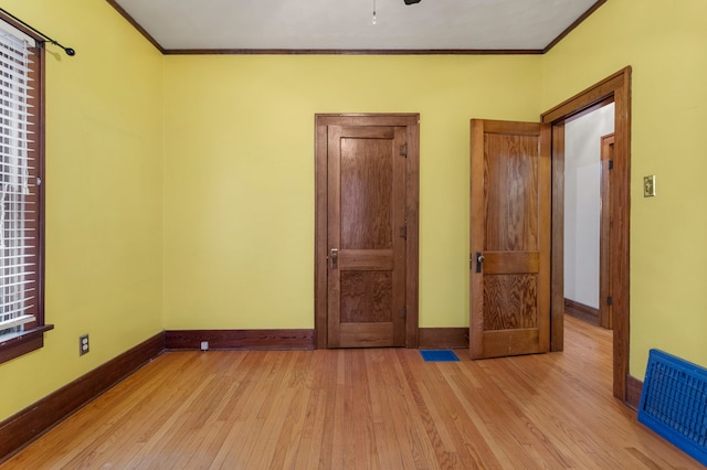 unfurnished bedroom with baseboards, ornamental molding, and wood finished floors