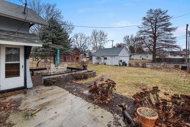 view of yard featuring a garden, fence, an outdoor structure, and a patio