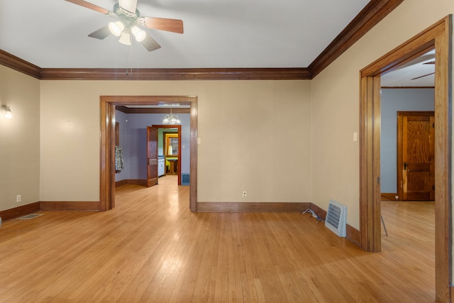 unfurnished room featuring baseboards, light wood-type flooring, and crown molding