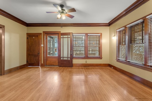 entrance foyer with ornamental molding, light wood-type flooring, a ceiling fan, and baseboards