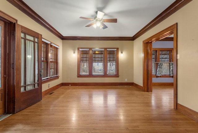 unfurnished room featuring light wood-style flooring, visible vents, ornamental molding, and baseboards