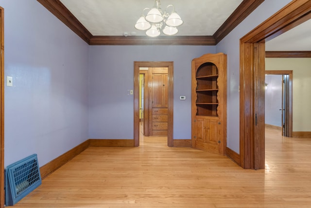 empty room with light wood finished floors, baseboards, visible vents, ornamental molding, and a chandelier