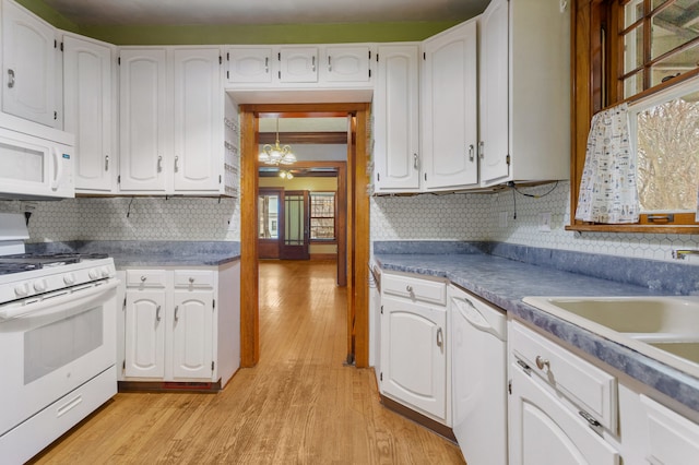 kitchen with white appliances, white cabinetry, backsplash, and light wood-style floors