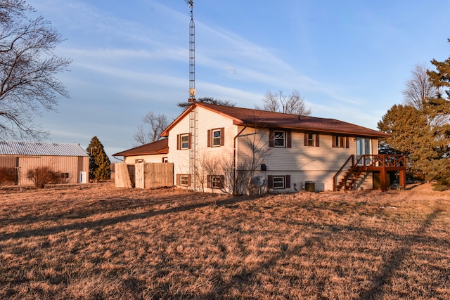 rear view of house with central AC unit, fence, stairs, a yard, and a wooden deck