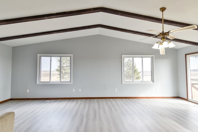 spare room featuring a wealth of natural light, vaulted ceiling with beams, baseboards, and wood finished floors