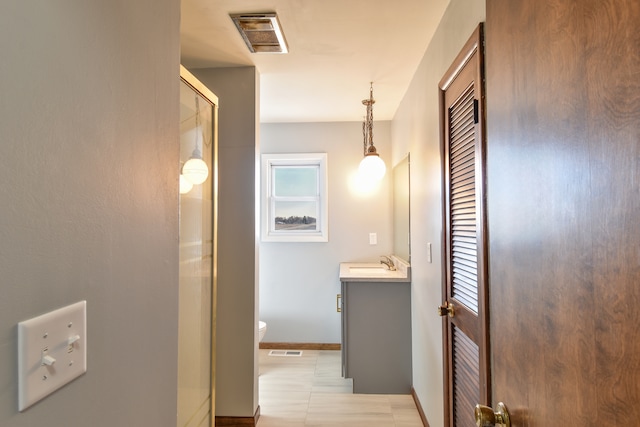 full bathroom featuring toilet, a shower with shower door, visible vents, and vanity