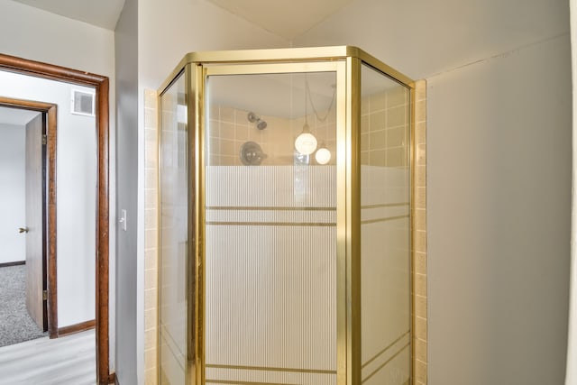 bathroom with a shower stall and visible vents