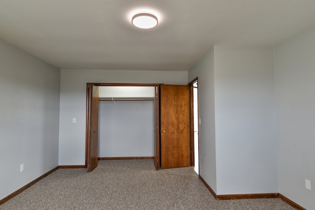 unfurnished bedroom with a closet, carpet flooring, and baseboards