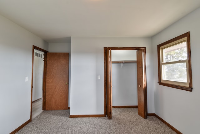 unfurnished bedroom featuring baseboards, carpet, visible vents, and a closet