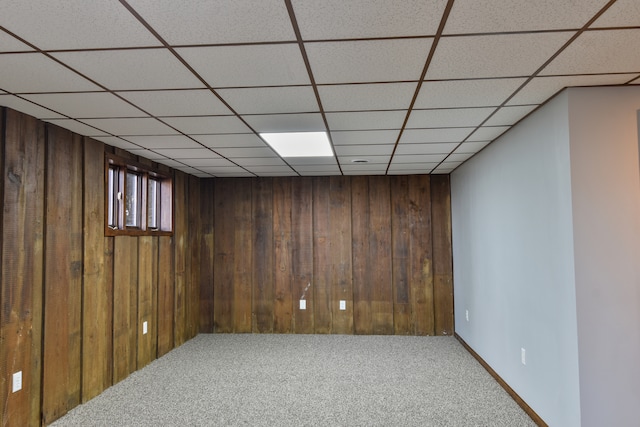 basement with carpet flooring and wood walls