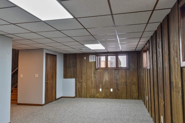 below grade area with carpet, wood walls, and baseboards