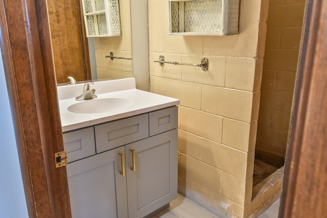 bathroom with concrete block wall and vanity