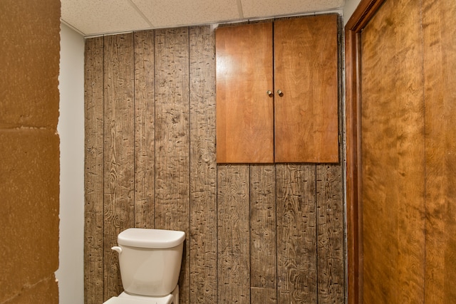 bathroom with a paneled ceiling and toilet