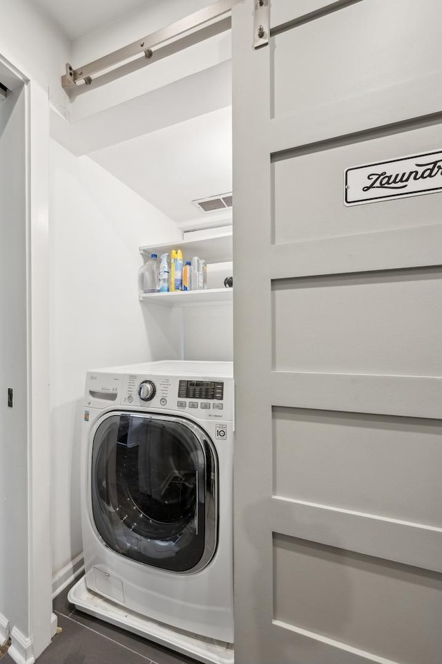 washroom featuring a barn door and washer / dryer