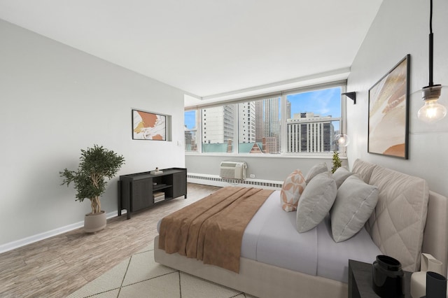 bedroom featuring hardwood / wood-style flooring and a wall unit AC