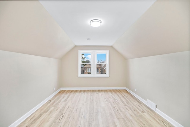 bonus room with lofted ceiling and light hardwood / wood-style floors