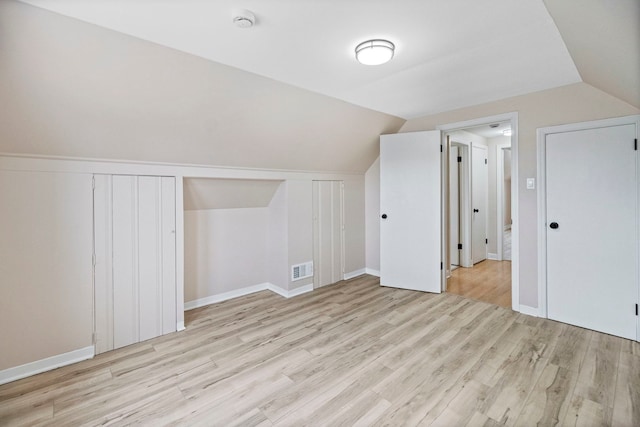 additional living space featuring lofted ceiling and light hardwood / wood-style flooring