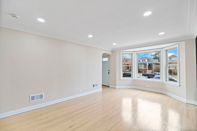 empty room featuring ornamental molding and light hardwood / wood-style flooring