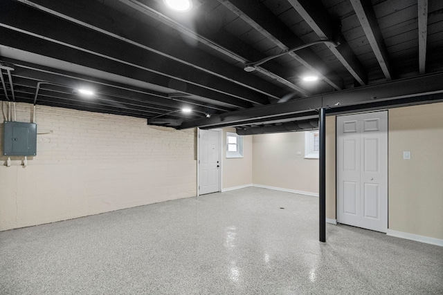 basement with electric panel and brick wall