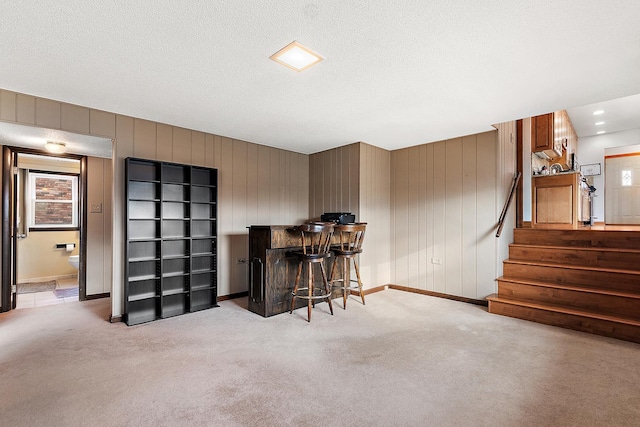 office space with indoor bar, light carpet, and a textured ceiling