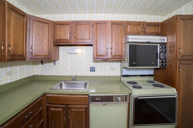 kitchen featuring dishwasher, sink, and white range with electric cooktop