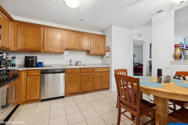 kitchen with stainless steel appliances, sink, and light tile patterned floors