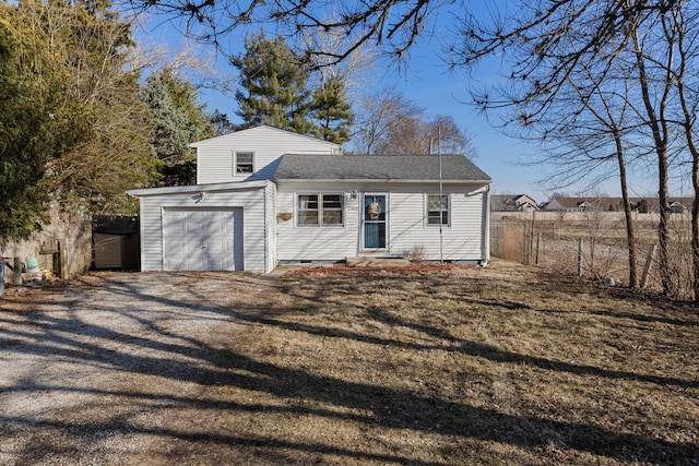 tri-level home with a garage, driveway, and fence