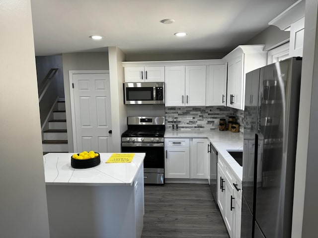 kitchen featuring stainless steel appliances, backsplash, and white cabinetry