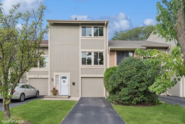 view of property featuring a garage and a front lawn