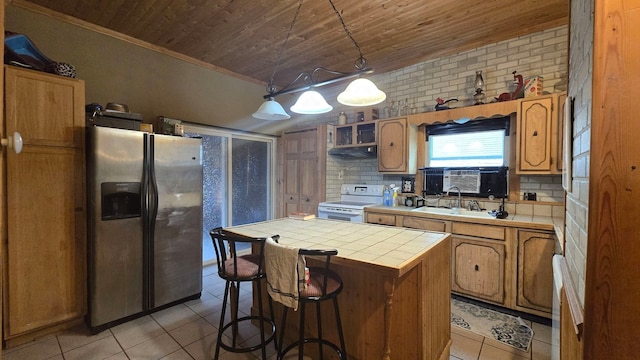 kitchen featuring white range with electric cooktop, a kitchen island, tile countertops, and stainless steel fridge with ice dispenser