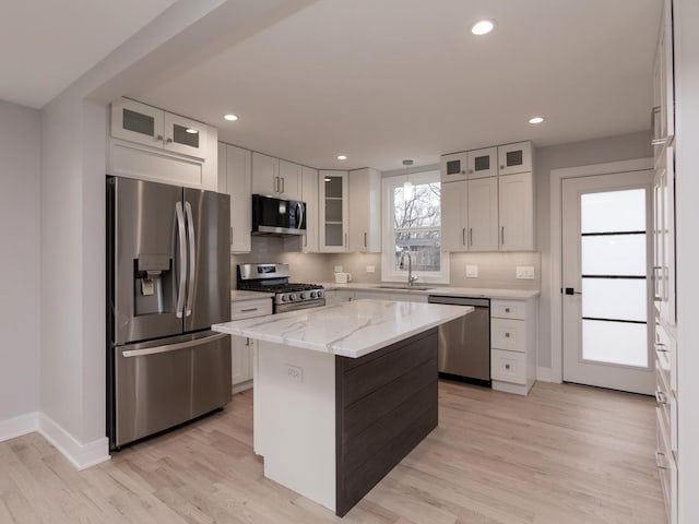 6310 Hilly Way, Cary, IL 60013 - kitchen featuring stainless steel appliances, white cabinetry, backsplash, light stone countertops, and light wood-style flooring