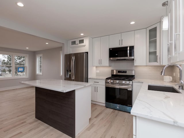 6310 Hilly Way, Cary, IL 60013 - kitchen featuring stainless steel appliances, light wood-style flooring, decorative backsplash, a center island, and light stone counters
