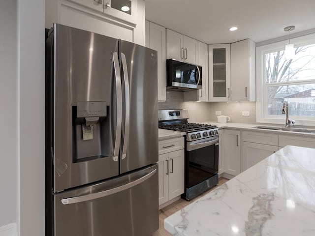 6310 Hilly Way, Cary, IL 60013 - kitchen with stainless steel appliances, white cabinetry, glass insert cabinets, tasteful backsplash, and light stone countertops