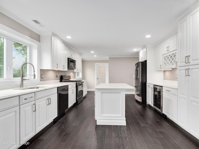 kitchen with sink, white cabinets, beverage cooler, a center island, and black appliances