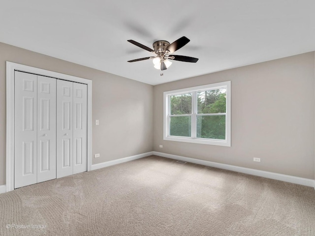 unfurnished bedroom with ceiling fan, carpet flooring, and a closet