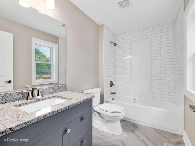 full bathroom with vanity, tiled shower / bath, and toilet