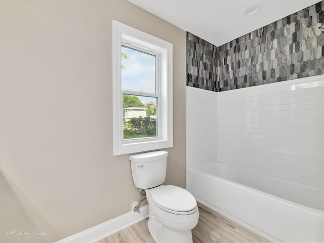 bathroom featuring hardwood / wood-style flooring, a tub, and toilet