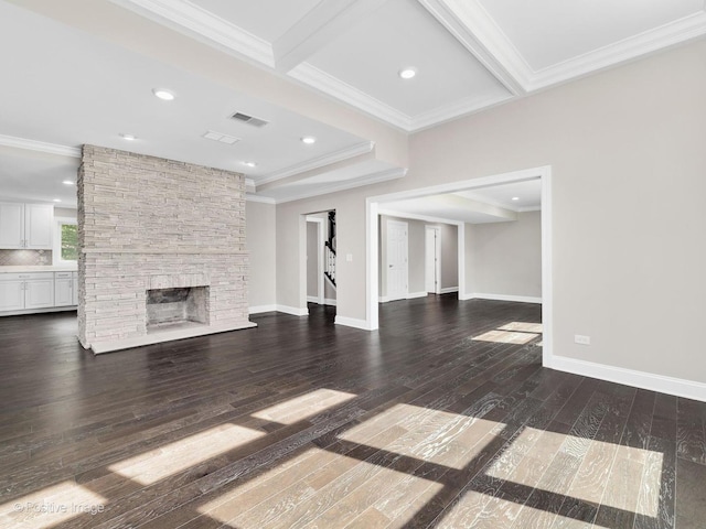 unfurnished living room with a fireplace, beam ceiling, dark wood-type flooring, and ornamental molding