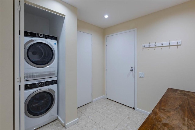 laundry room with stacked washing maching and dryer and light tile patterned floors