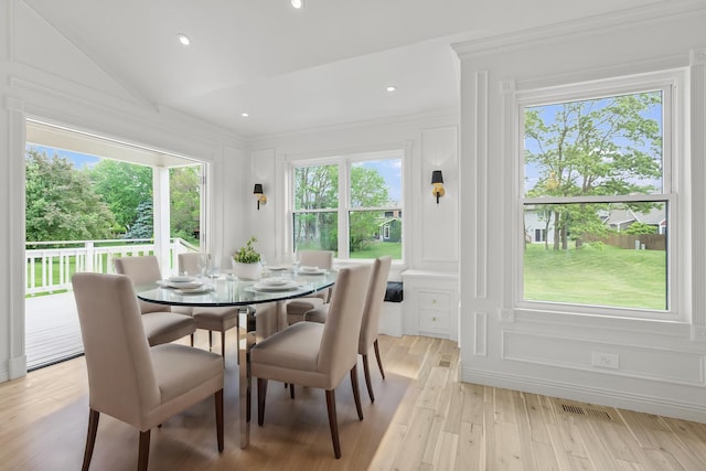 dining space featuring vaulted ceiling and light wood-type flooring