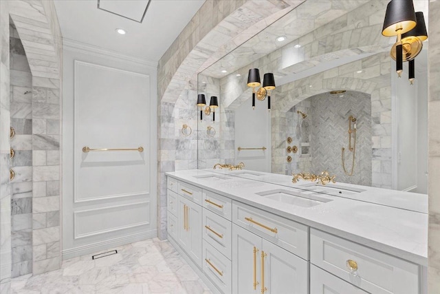 bathroom featuring crown molding, vanity, and a tile shower