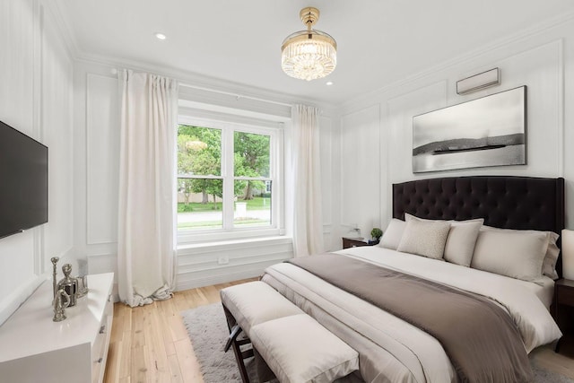 bedroom with crown molding, a chandelier, and light hardwood / wood-style floors