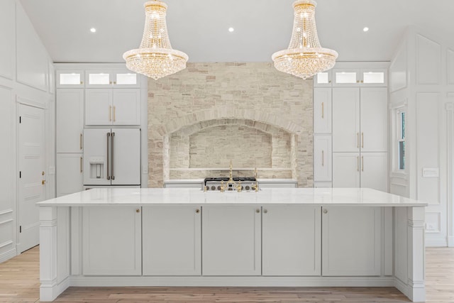 kitchen with white cabinetry, decorative light fixtures, and high end white fridge