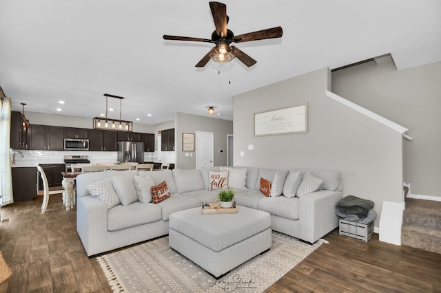 living room with dark wood-type flooring and ceiling fan