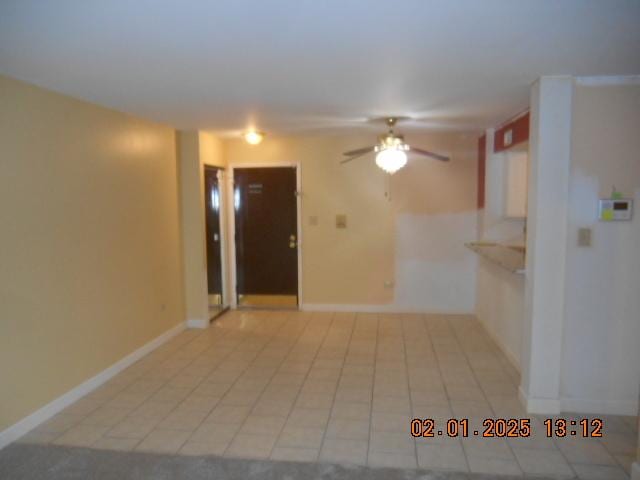 tiled spare room featuring ceiling fan