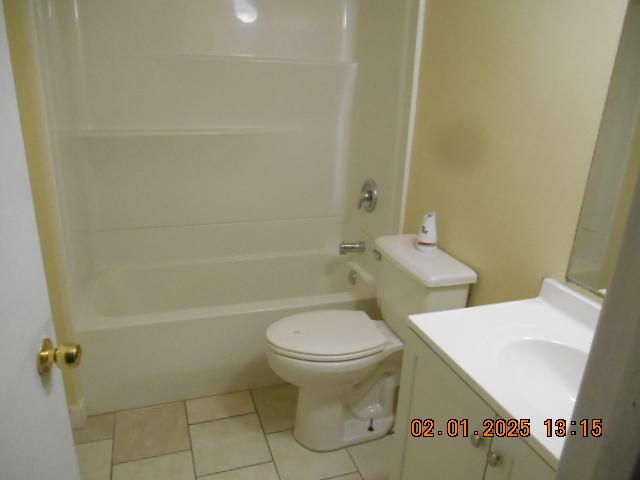 full bathroom with vanity, tile patterned flooring, toilet, and washtub / shower combination