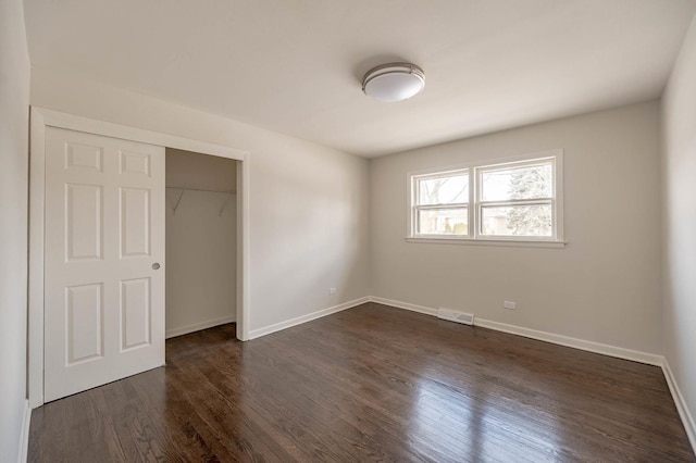 unfurnished bedroom featuring dark hardwood / wood-style flooring and a closet