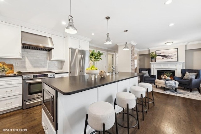 kitchen with white cabinetry, wall chimney range hood, pendant lighting, and appliances with stainless steel finishes