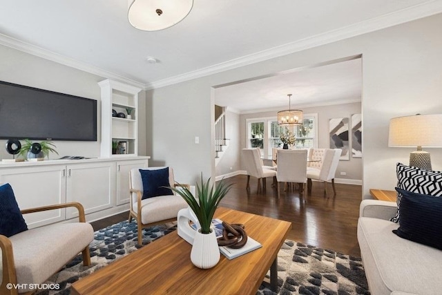 living room with crown molding, dark wood-type flooring, and a notable chandelier