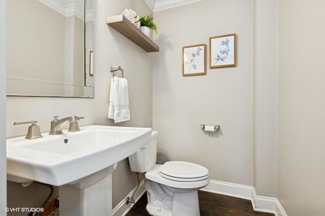 bathroom with hardwood / wood-style floors, ornamental molding, sink, and toilet